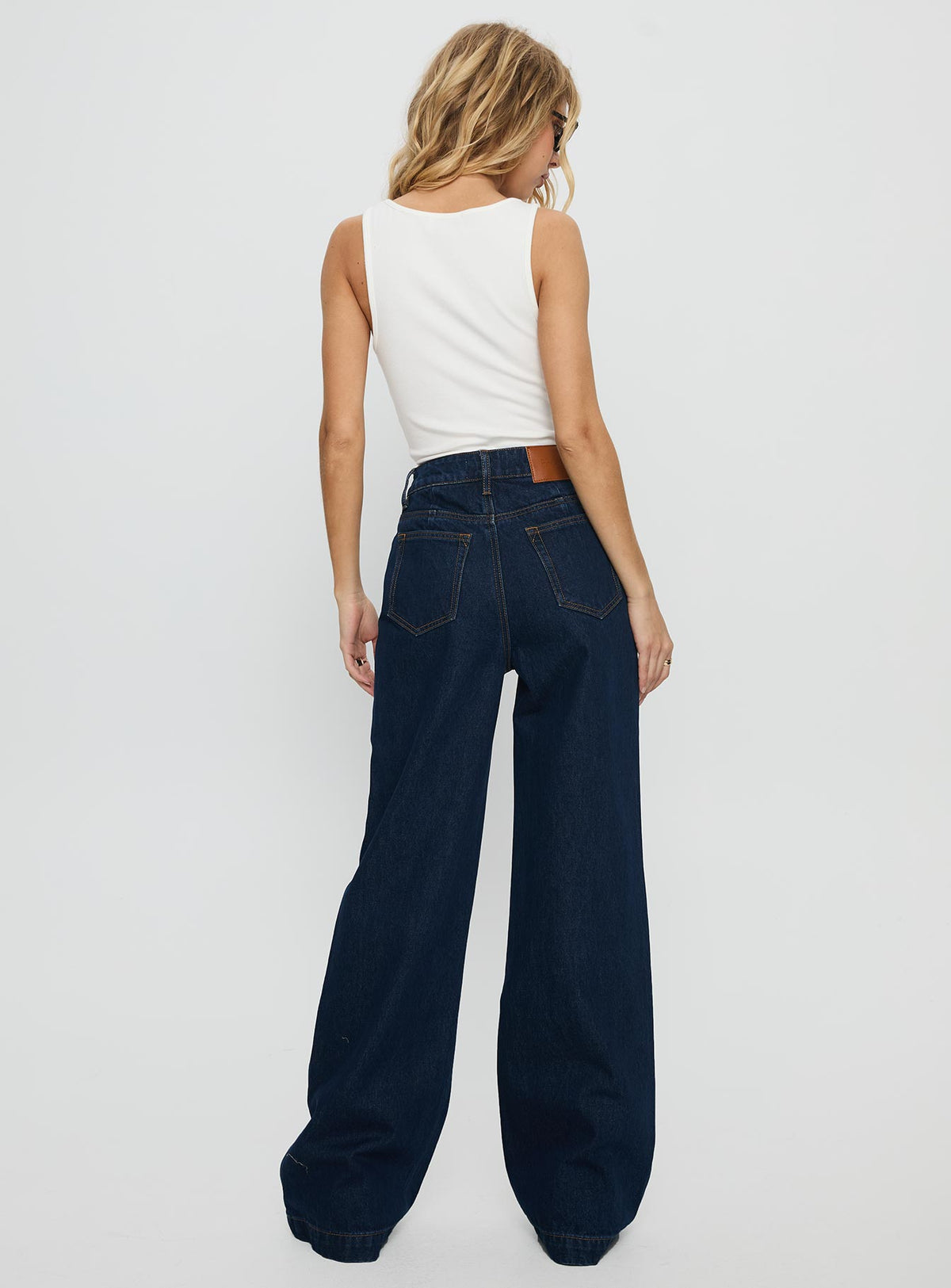 back view of model wearing Princess Polly Goldie High Rise Wide Leg Jeans Indigo High Rise Jeans Jeans 