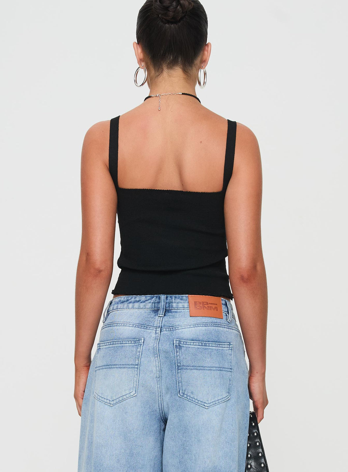 back view of model wearing Princess Polly Dalma Twist Top Black Sleeveless Sweetheart 