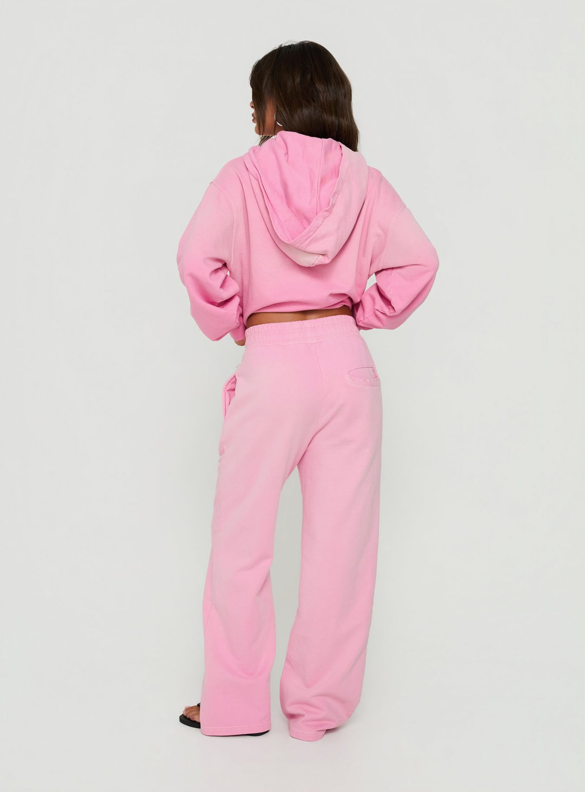 Displaying the AT Fleece Baggy Sweatpant Washed Pink in womens-regular-pants with mid-rise waist back view of model wearing Princess Polly