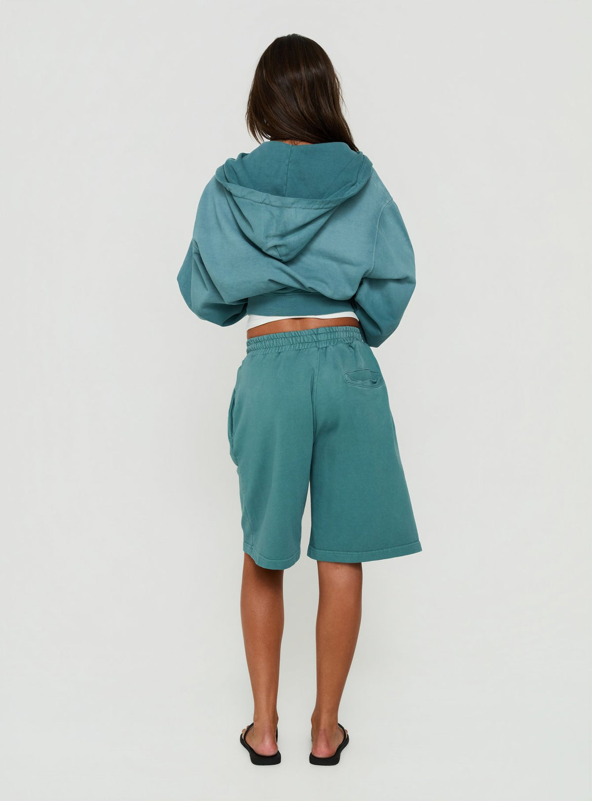 Featuring the AT Fleece Baggy Jort in Washed Teal womens regular pants with mid-rise back view of model wearing Princess Polly