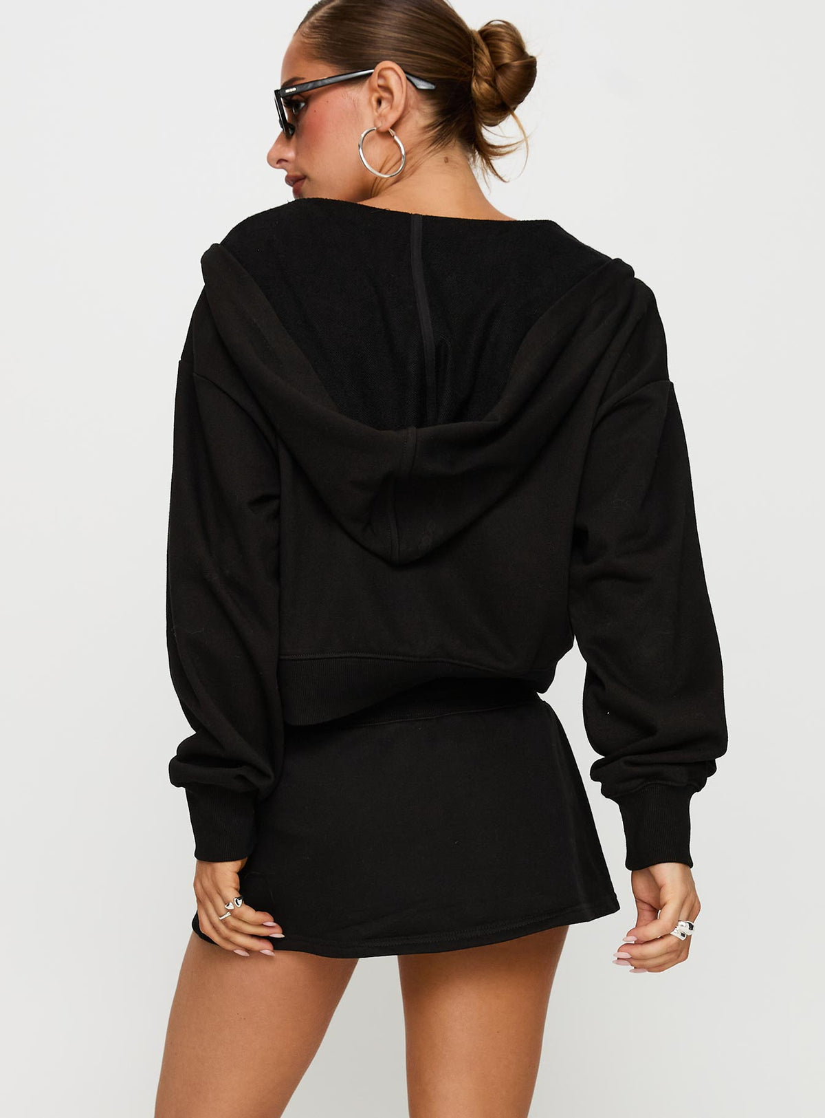 back view of model wearing Princess Polly Down Low Fleece Skort Black Low Rise Shorts 