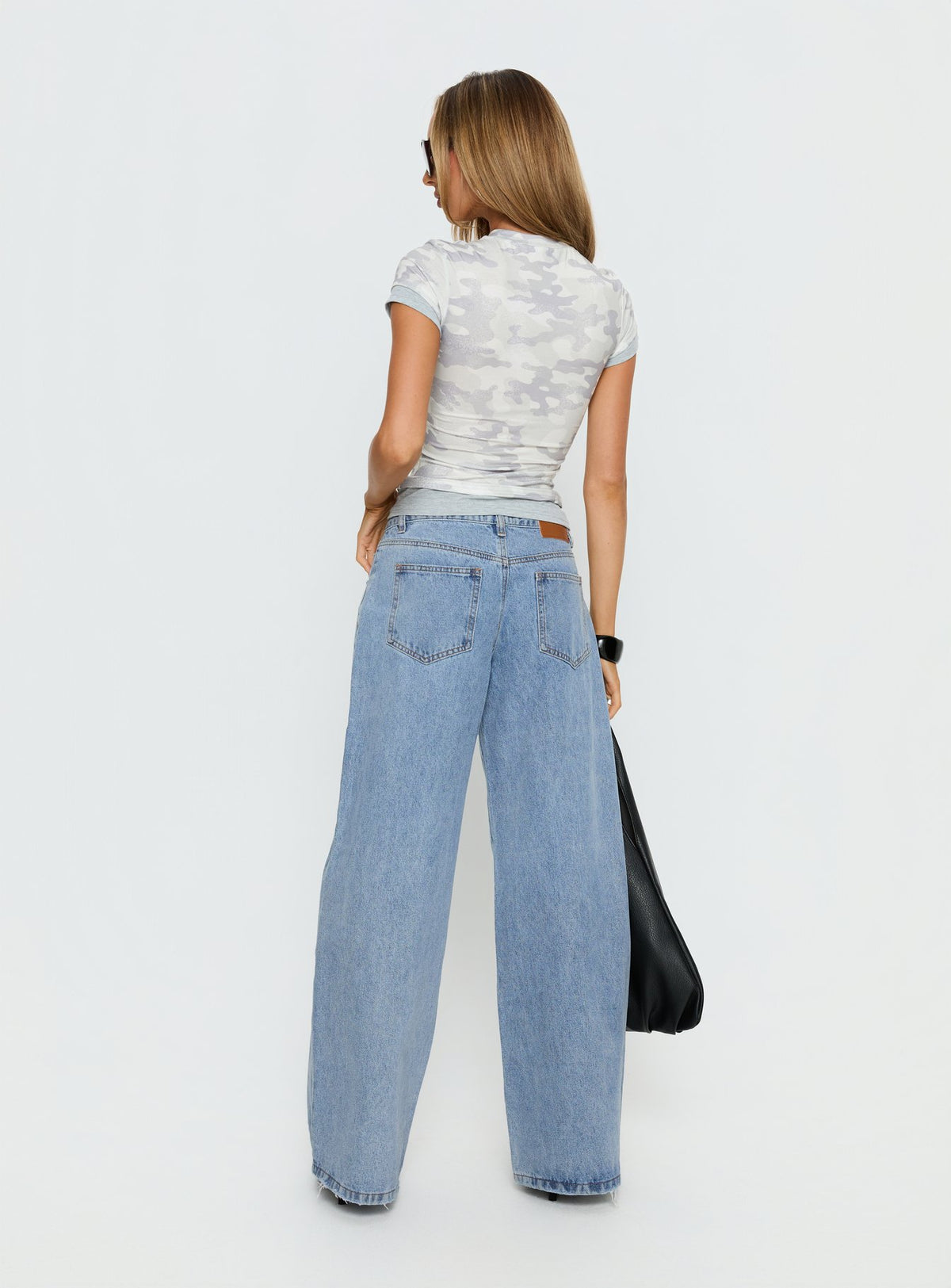 Presenting Candi Mid Rise Wide Leg Studded Jeans in a light blue wash, womens-jeans featuring mid-rise waist back view of model wearing Princess Polly