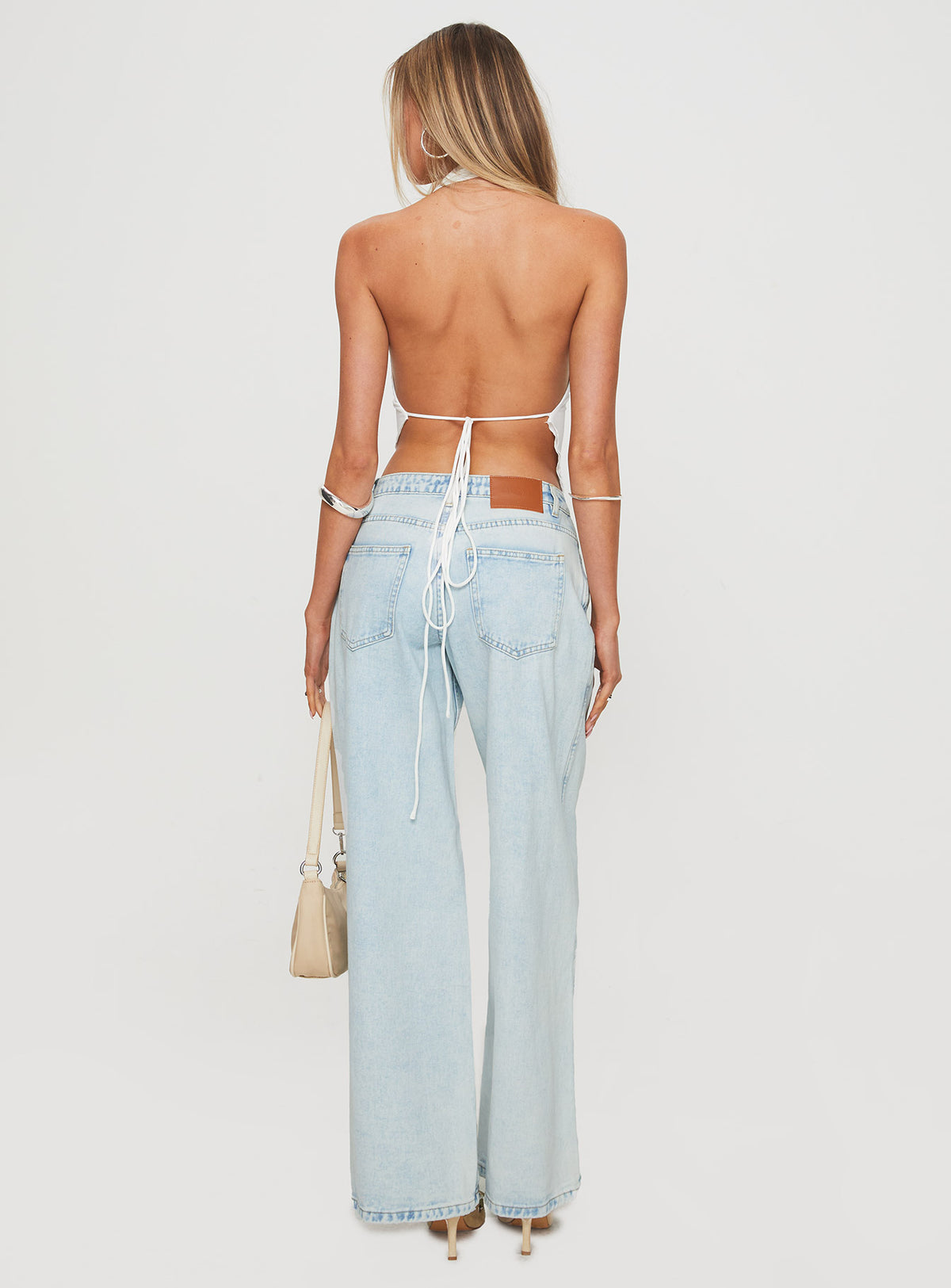 back view of model wearing Princess Polly Brayden Low Rise Relaxed Jeans Light Acid Wash Low Rise Jeans Jeans 