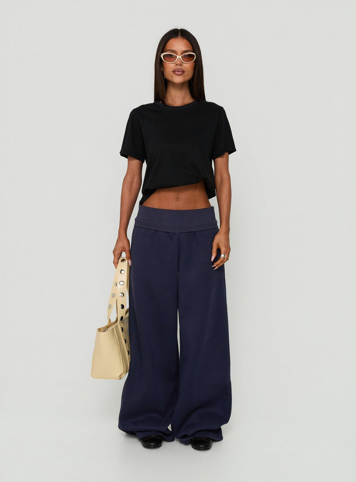 Showcasing the Lockie Foldover Baggy Track Pants Navy womens-regular-pants with low-rise front view of model wearing Princess Polly