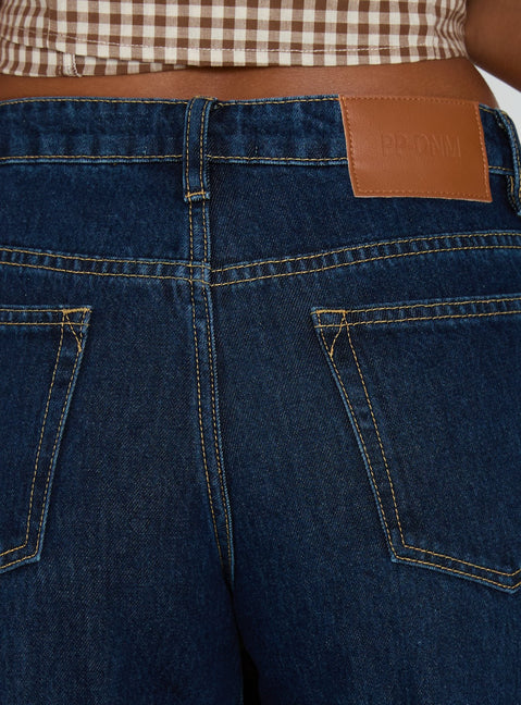 back view of model wearing Princess Polly Darla Low Rise Straight Leg Cuff Jean Dark Blue Wash Low Rise Jeans Jeans 