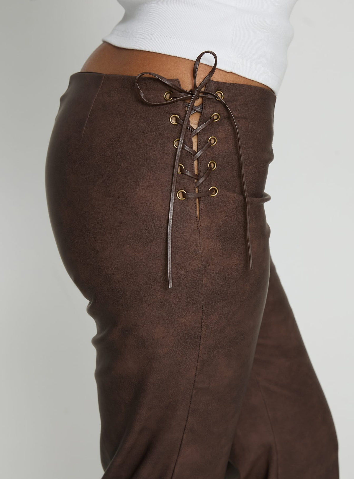 side view of model wearing Princess Polly Trickrider Tie Side Faux Leather Pants Chocolate Mid Rise Pants Pants 