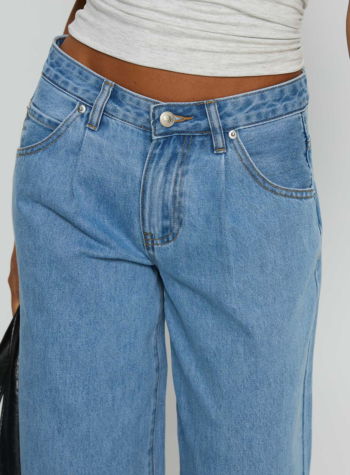 side view of model wearing Princess Polly Supercut Low Rise Baggy Pleat Jeans Light Blue Wash Low Rise Jeans Jeans 