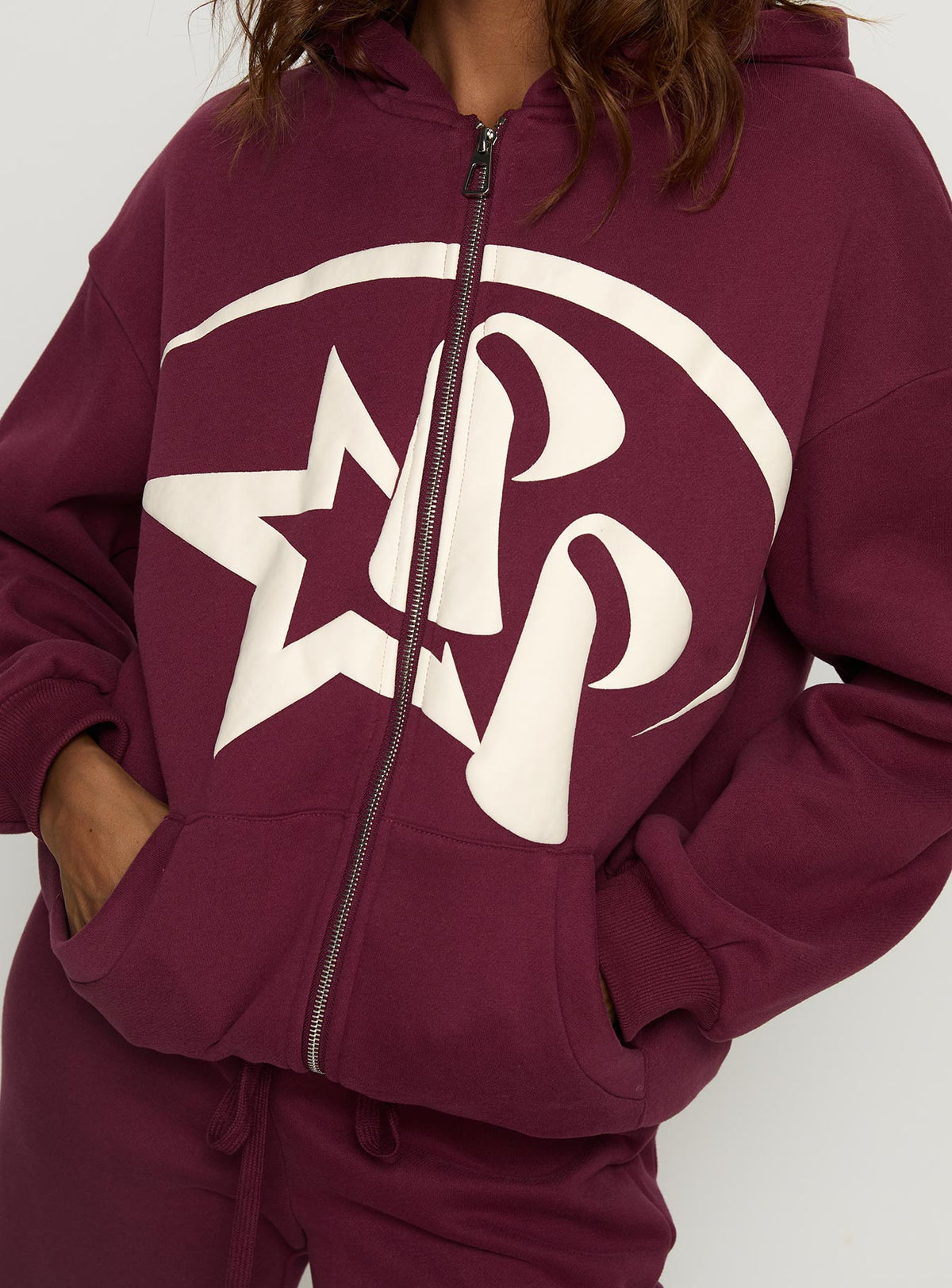 Highlighting the Stargirl Zip Through Jumper in Burgundy womens jumpers with long fit showcasing graphic detail Princess Polly