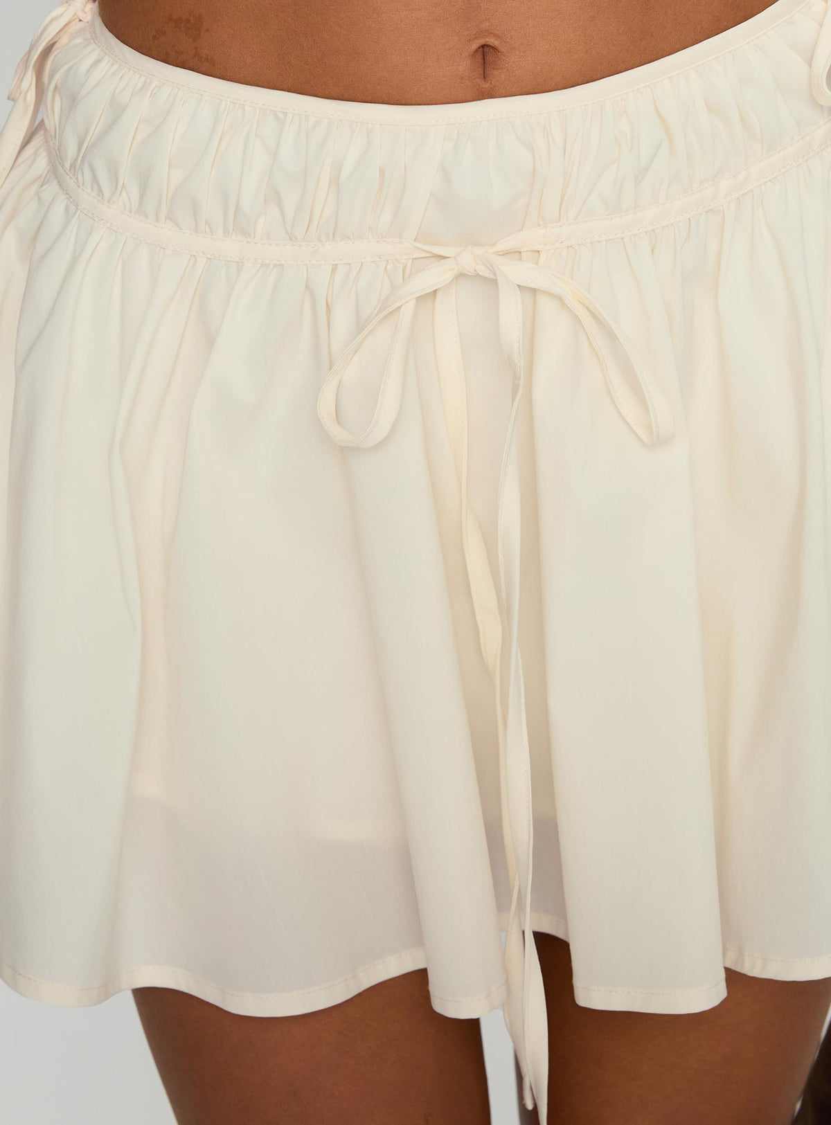 back view of model wearing Princess Polly Astelle Tie Up Mini Skirt Cream Mini Skirts Skirts 
