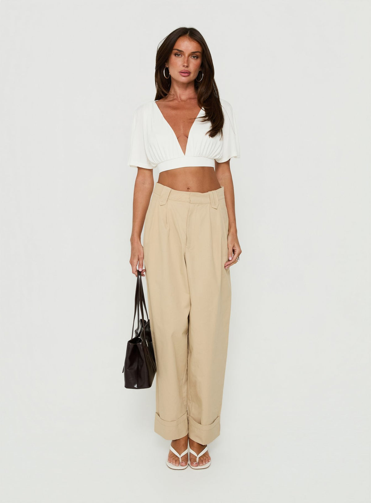 Showcasing the Kendall Pant Sand womens-regular-pants with high-rise pleated wide-leg construction in tan front view of model wearing