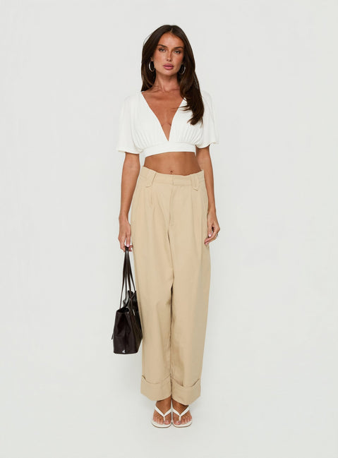 Showcasing the Kendall Pant Sand womens-regular-pants with high-rise pleated wide-leg construction in tan front view of model wearing