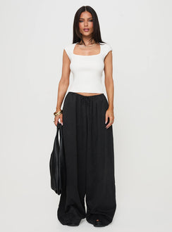 Showcasing the Bungala Oversized Relaxed Pants Black Tall wide-leg womens regular pants in mid-rise front view of model wearing Princess Polly