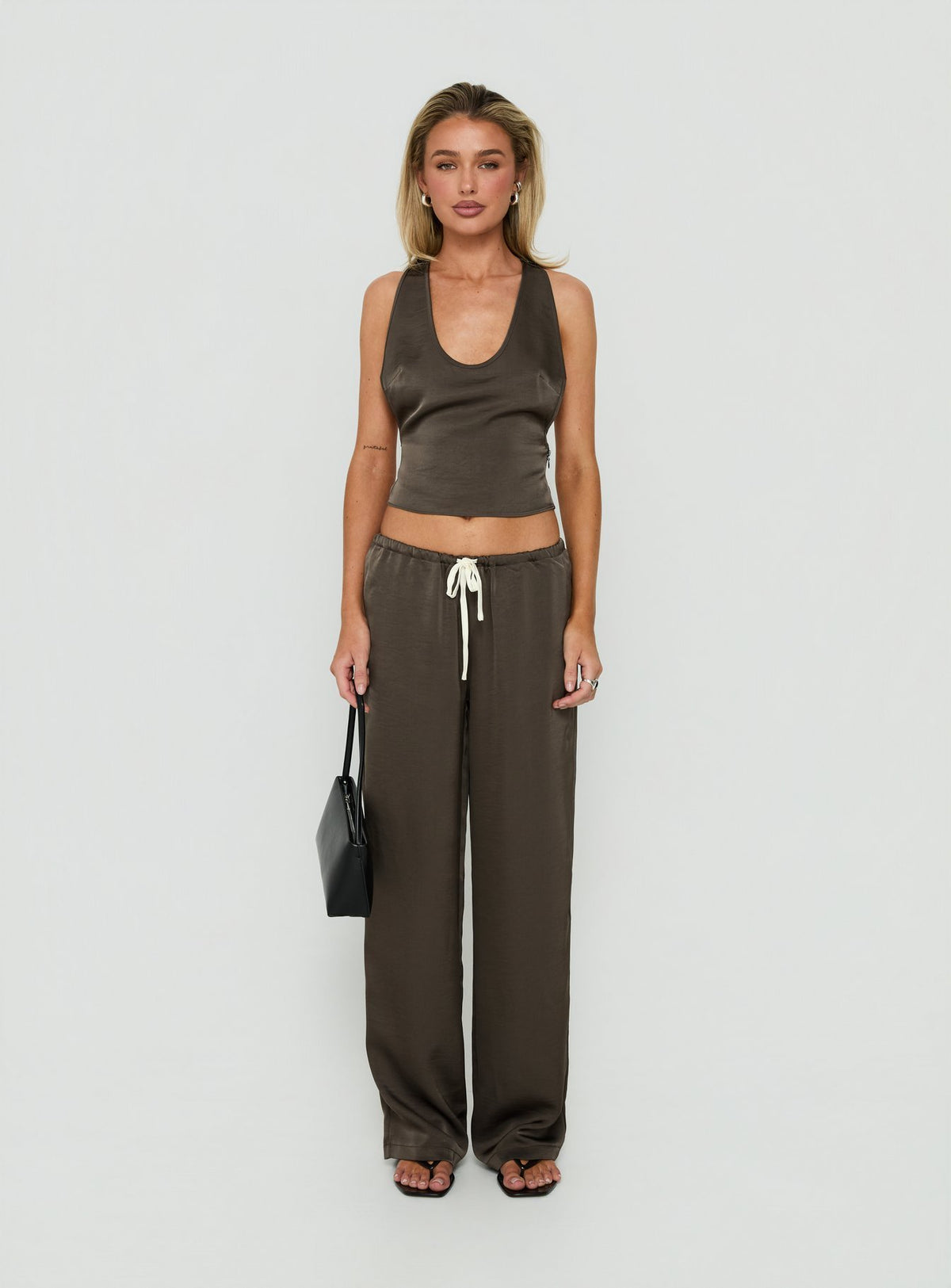 Showcasing the Dialled Up Tie Waist Satin Pants Mocha in womens regular pants with mid-rise detail front view of model wearing Princess Polly