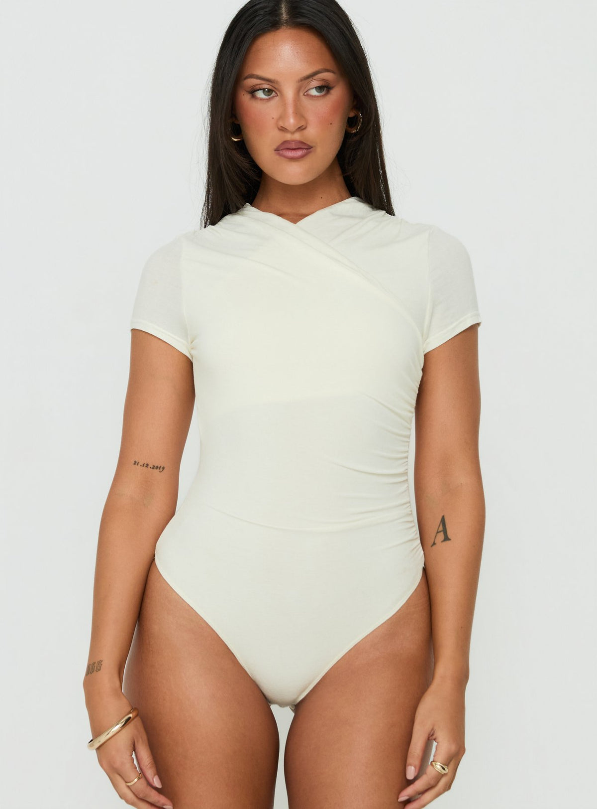 Discover the Odettea Cross Front Short Sleeve Bodysuit in Cream womens-bodysuit with short sleeves front view of model wearing Princess Polly