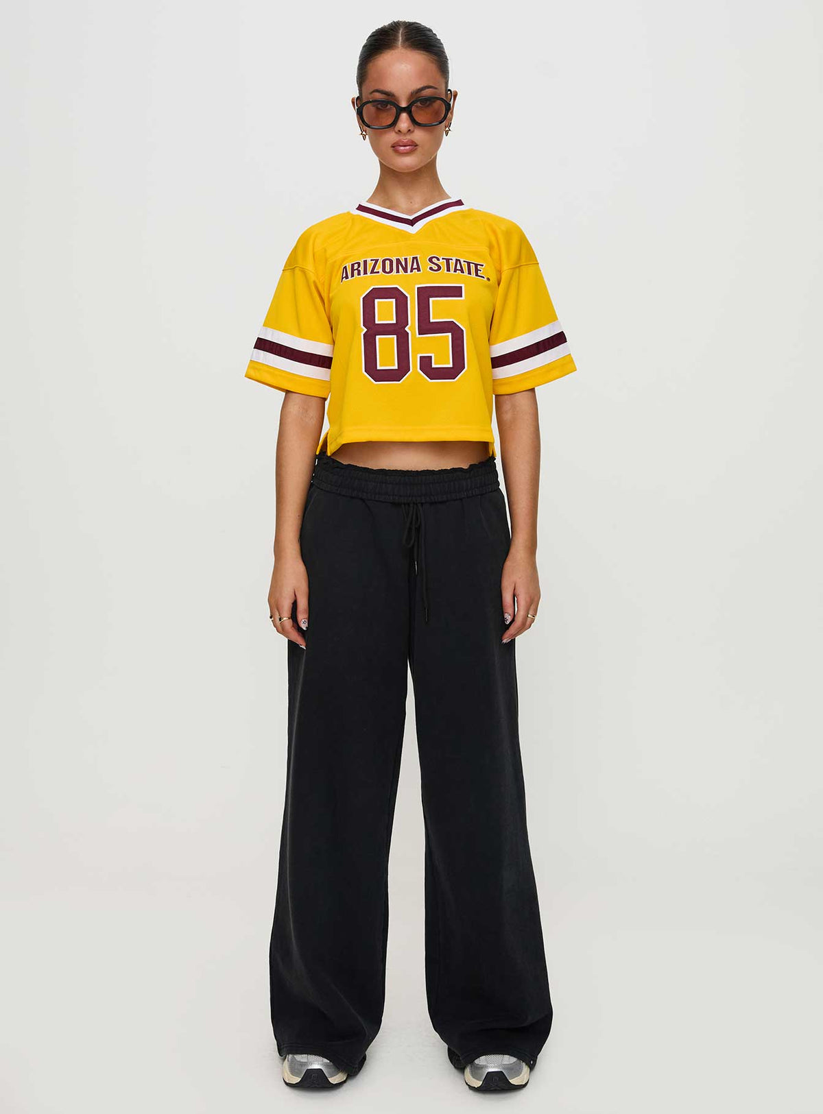 side view of model wearing Princess Polly ASU Football Jersey Gold Half Sleeves V-Neck 