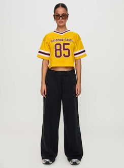 side view of model wearing Princess Polly ASU Football Jersey Gold Half Sleeves V-Neck 