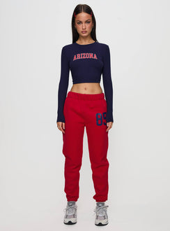 side view of model wearing Princess Polly U of A Bring It Back Long Sleeve Top Navy Full Sleeves Crew Neck 