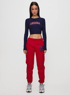 Crafted from red fleece, U of A Sweatpants in womens regular pants with mid-rise and graphic print, front view of model wearing