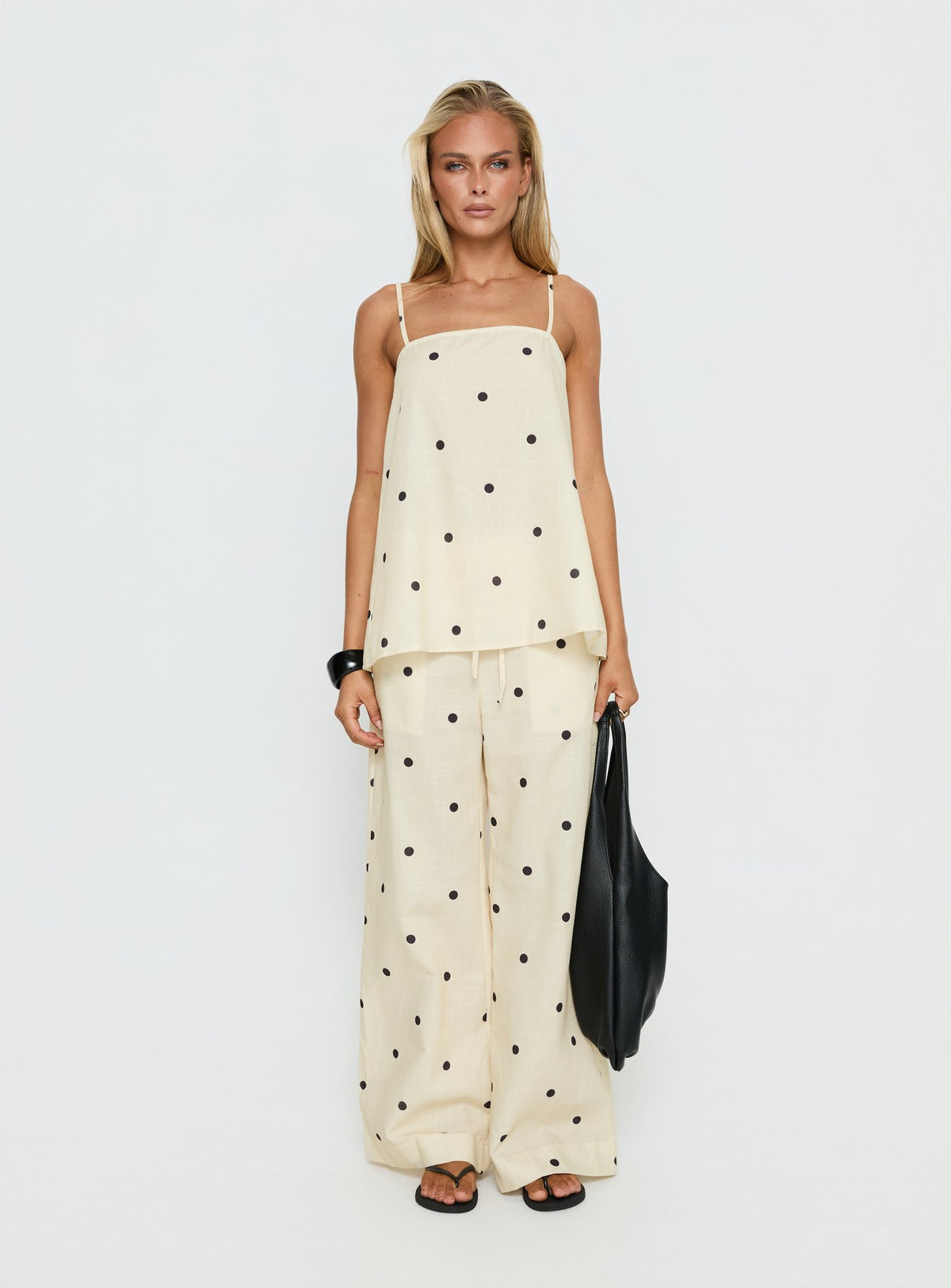 Showcasing Bellara Tie Waist Pants Yellow Polka in womens regular pants with mid-rise and wide-leg styling front view of model wearing Princess Polly