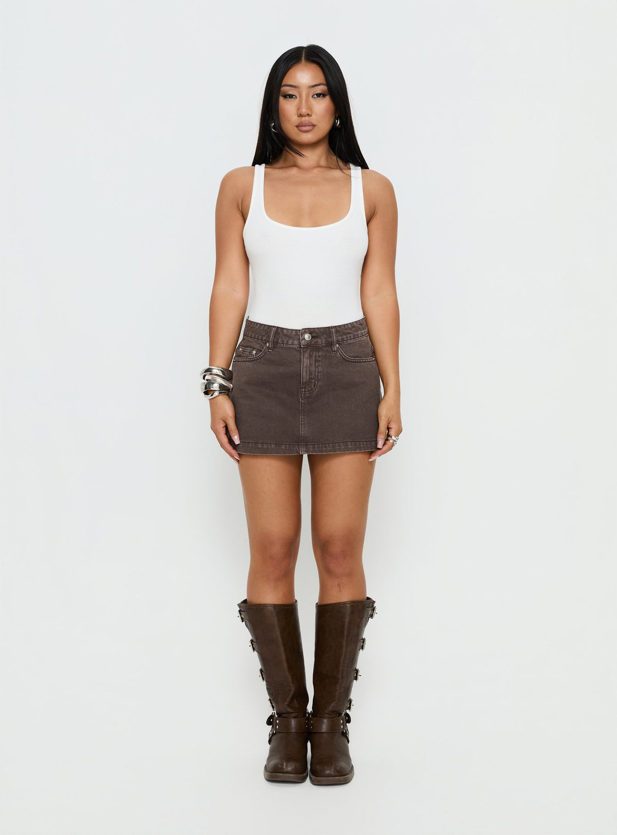   side view of model wearing Princess Polly Nicolina Low Rise Denim Mini Skirt Washed Brown Mini Skirts Skirts 