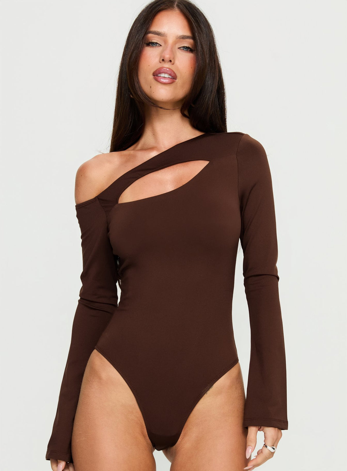front view of model wearing Princess Polly Raissa Cut Out One Shoulder Bodysuit Brown Long Sleeve Tops Bodysuit 