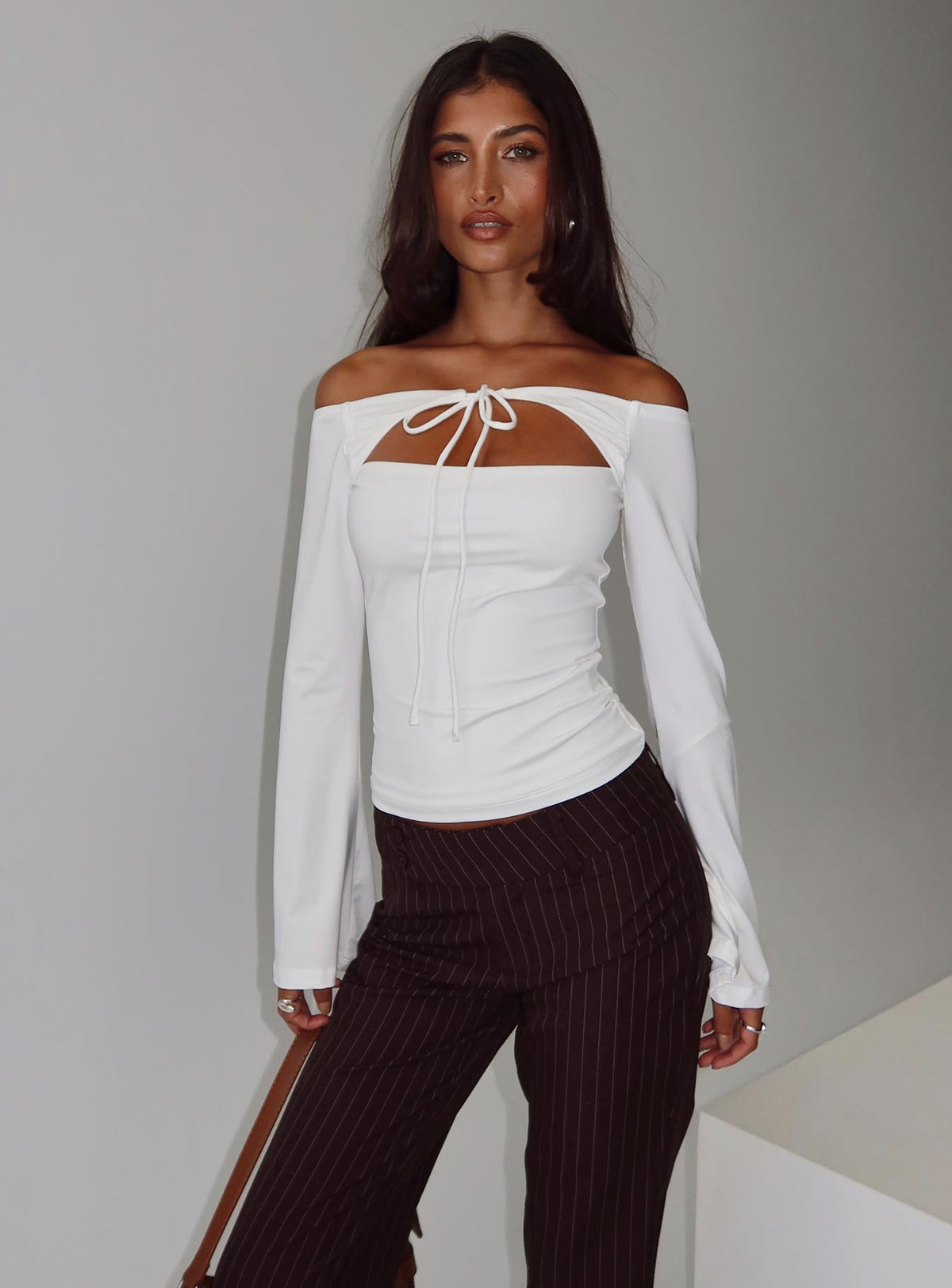 side view of model wearing Princess Polly Nevah Long Sleeve Top White Full Sleeves straight 