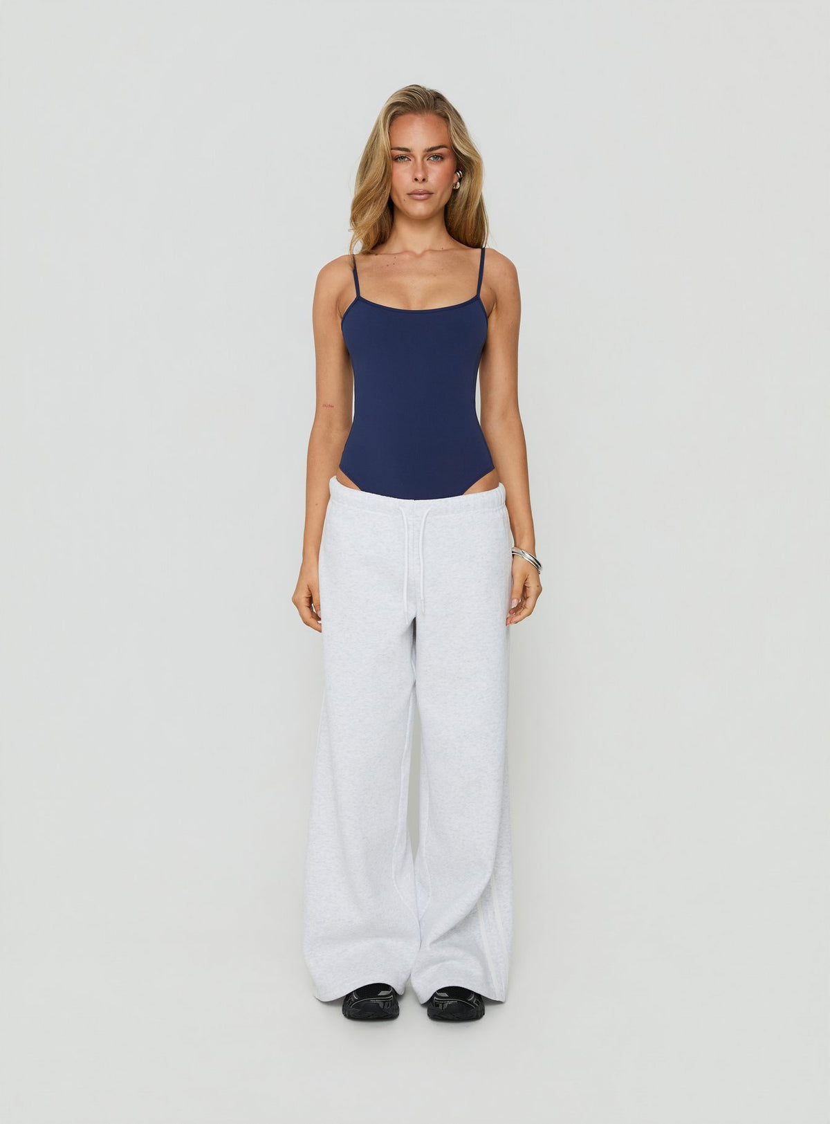 Designed with sleeveless construction, the Daily Define Thin Strap Low Back Bodysuit Navy womens-bodysuit back view of model wearing Princess Polly