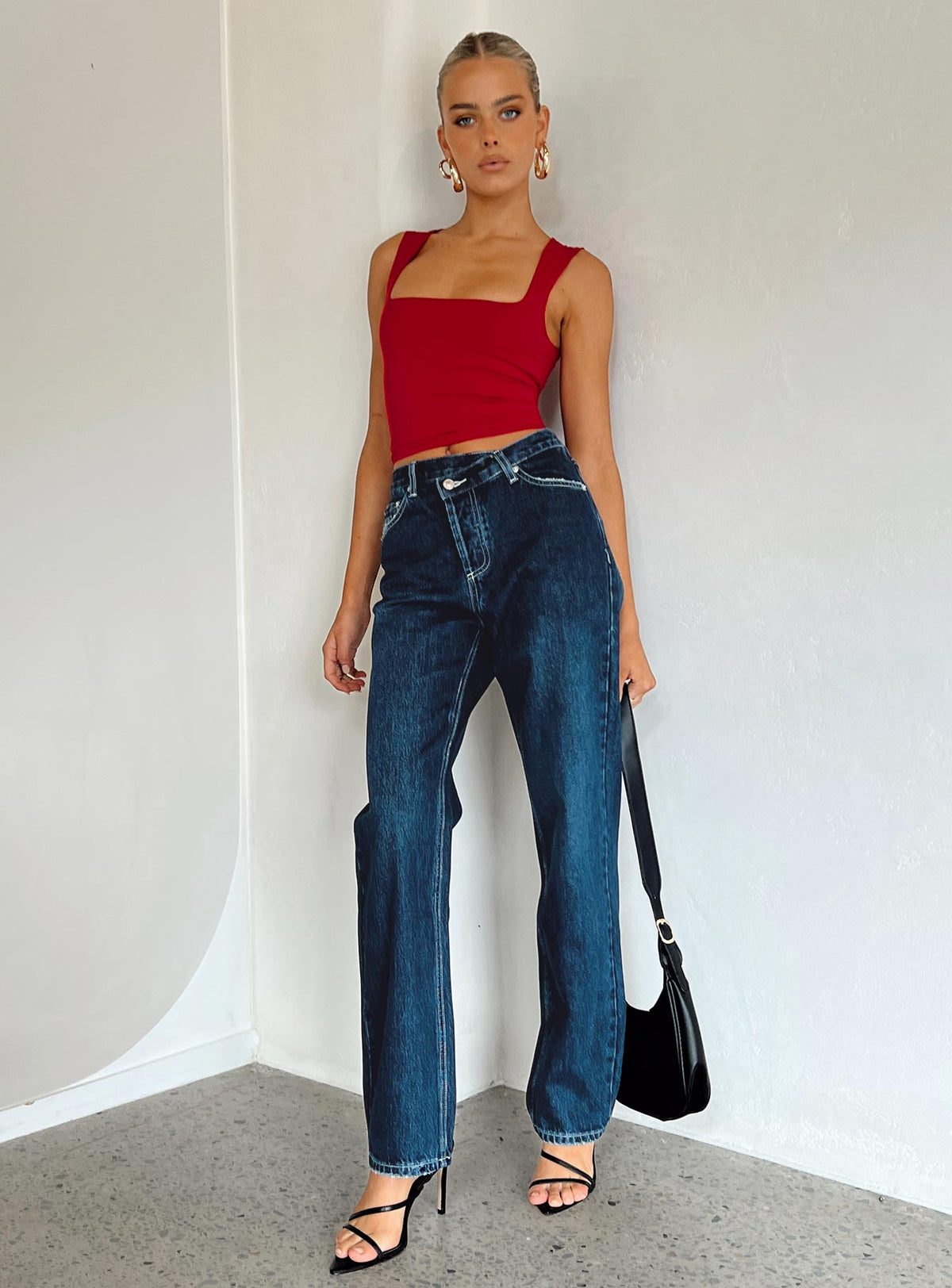 Front view of model wearing  front Princess Polly Mid Rise  Holly Asymmetric Straight Leg Jean Dark Wash Denim