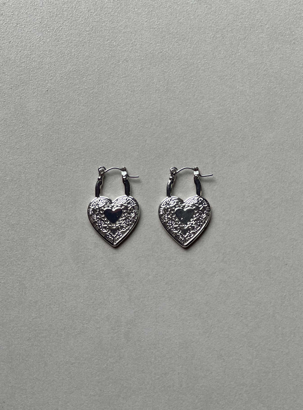 Earrings Hoop style  Silver-toned Latch fastening  Heart design